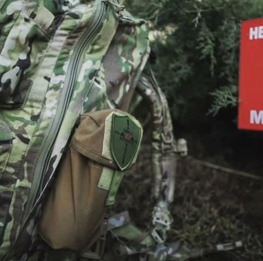 Multicam Squatch pack and medic pouch against conifer