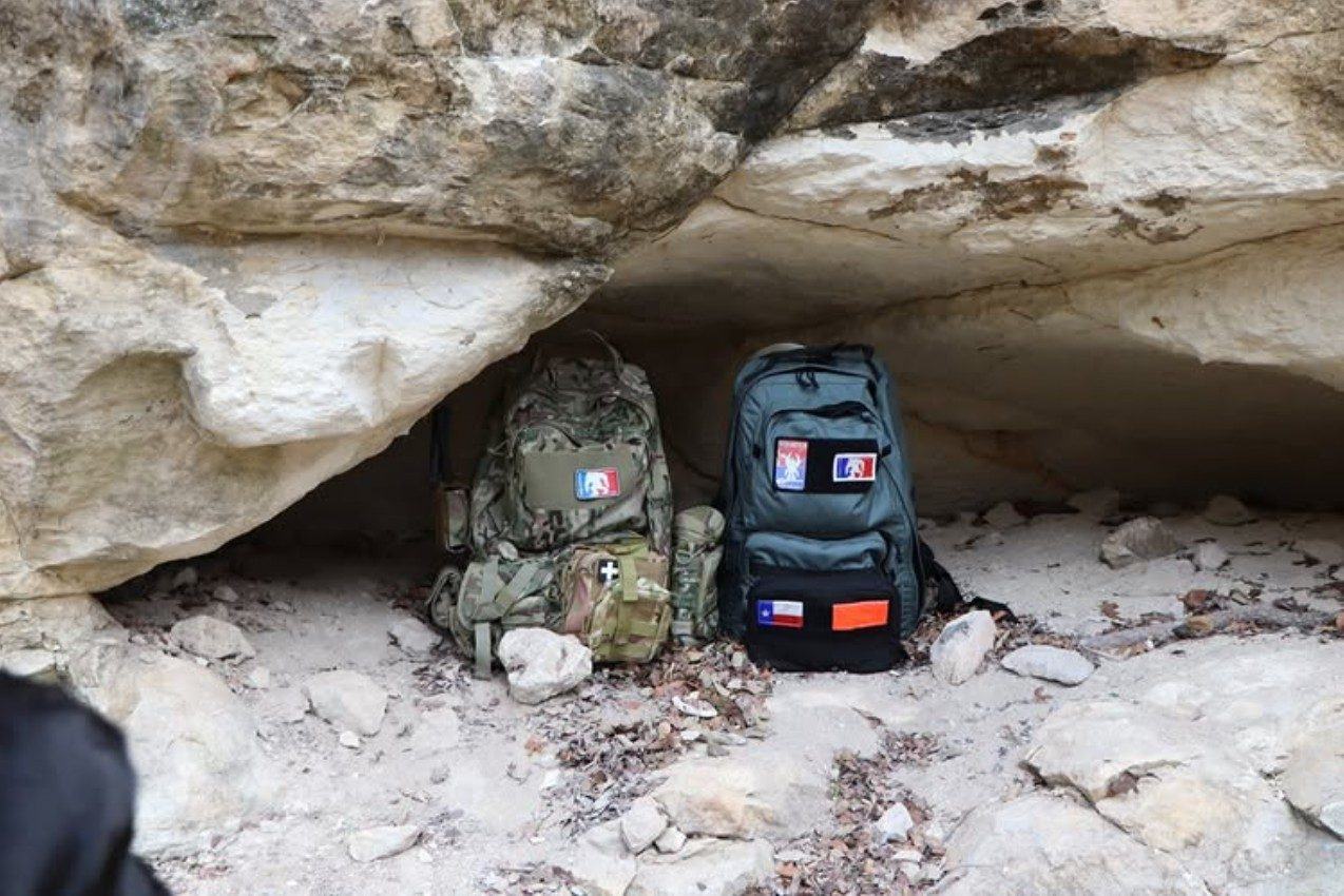 Two Squatch packs under a rock overhang